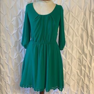 Green dress trimmed with lace & detail on sleeves